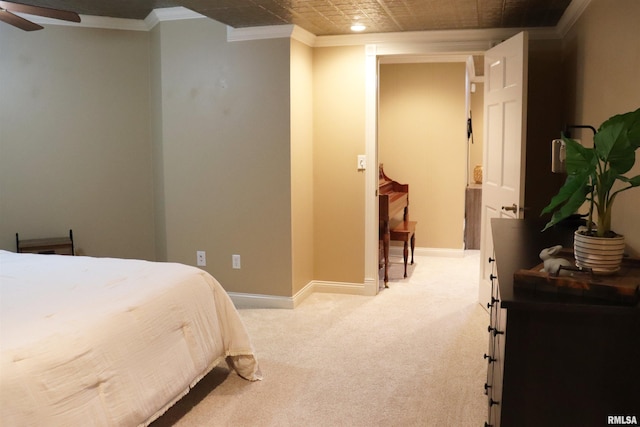 bedroom featuring crown molding, baseboards, and light carpet