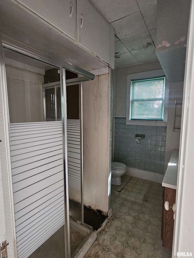 full bathroom with tile patterned floors, a stall shower, and toilet