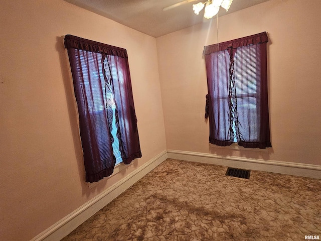 spare room featuring visible vents, baseboards, and ceiling fan