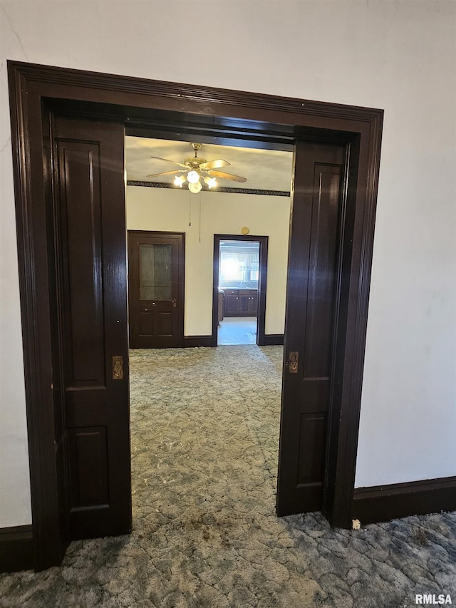 corridor with baseboards and carpet floors