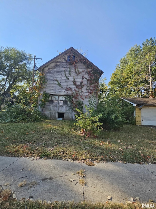 view of property exterior featuring an outbuilding and a lawn