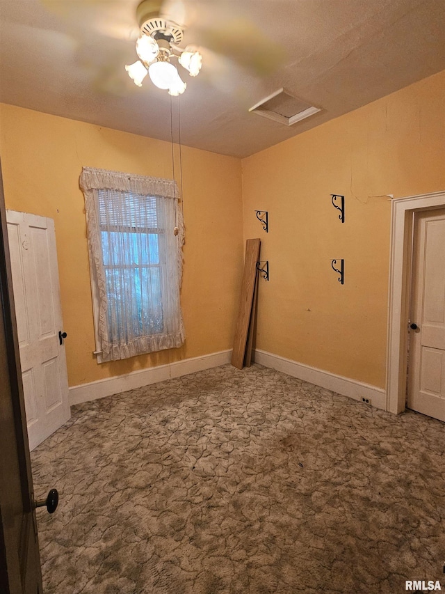 unfurnished room featuring attic access, carpet flooring, and baseboards