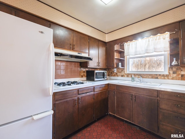 kitchen featuring white appliances, open shelves, a sink, light countertops, and under cabinet range hood