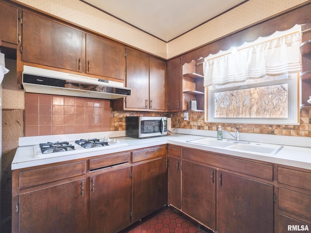 kitchen with open shelves, a sink, light countertops, under cabinet range hood, and stainless steel microwave