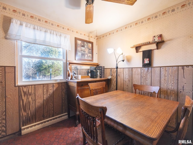 dining space featuring a wainscoted wall, wallpapered walls, ceiling fan, and a baseboard radiator