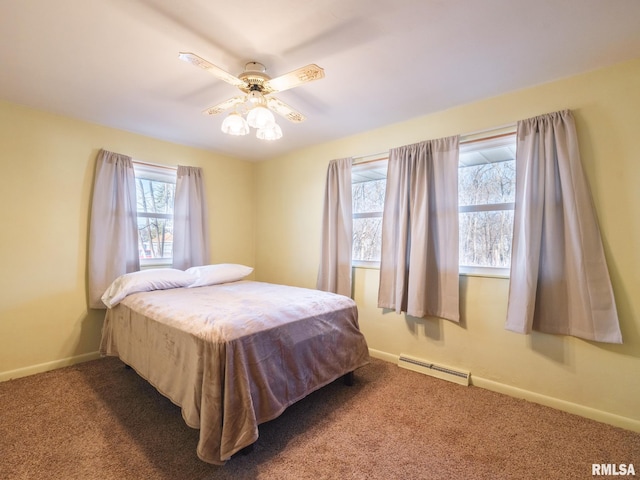 carpeted bedroom with baseboard heating, a ceiling fan, and baseboards