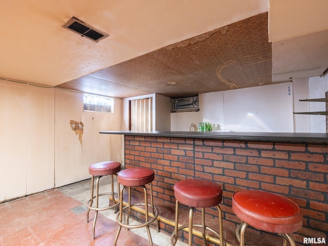 bar featuring visible vents, wood finished floors, and a dry bar