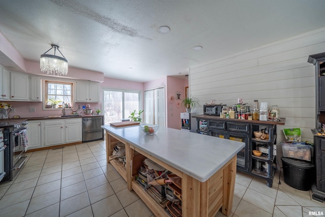 2268 E Knox St, Galesburg, IL 61401 - kitchen featuring a kitchen island, stainless steel electric stove, dishwasher, light tile patterned floors, and a sink