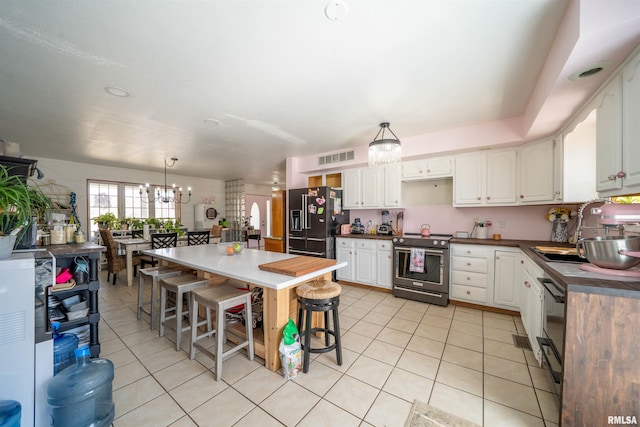2268 E Knox St, Galesburg, IL 61401 - kitchen with stainless steel electric range oven, an inviting chandelier, light tile patterned flooring, black fridge with ice dispenser, and a sink