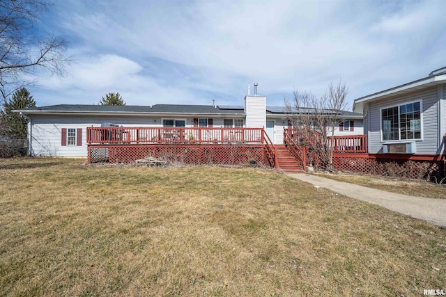 2268 E Knox St, Galesburg, IL 61401 - rear view of property with a chimney, roof mounted solar panels, a lawn, and a wooden deck