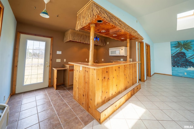 2268 E Knox St, Galesburg, IL 61401 - kitchen featuring lofted ceiling, light tile patterned floors, white microwave, and baseboards