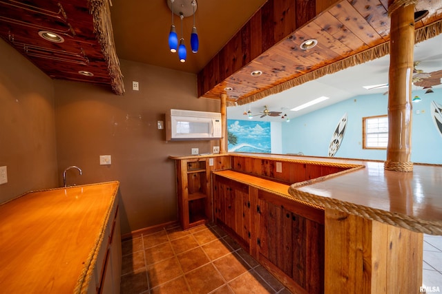 2268 E Knox St, Galesburg, IL 61401 - kitchen with white microwave, vaulted ceiling with skylight, tile patterned floors, and a sink