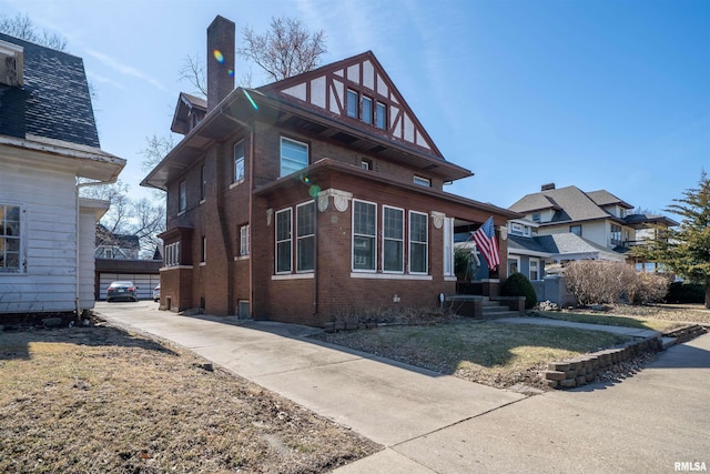 view of front of house with brick siding and a chimney