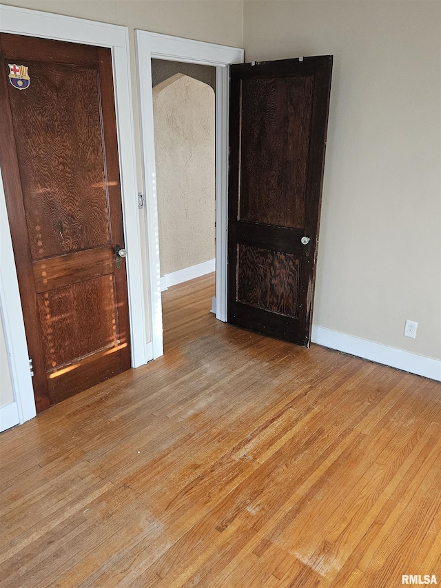 empty room with baseboards and light wood-style flooring