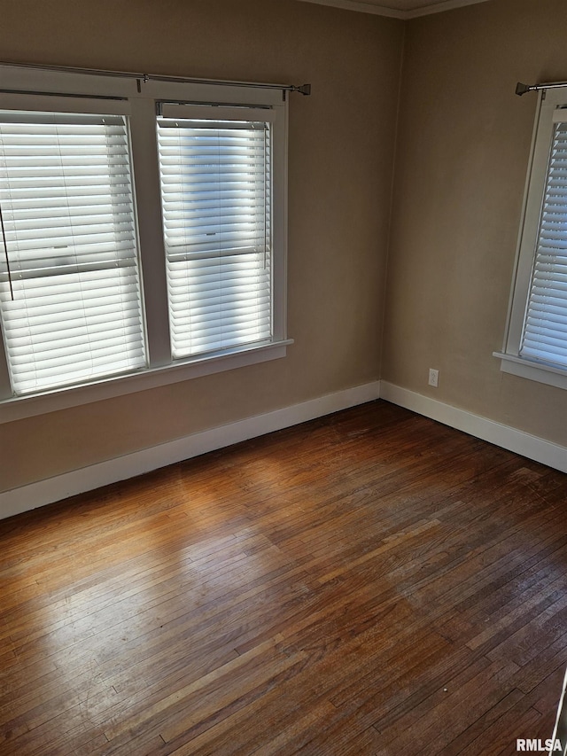 unfurnished room with baseboards and hardwood / wood-style floors