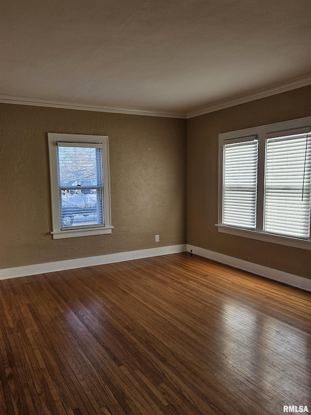 unfurnished room with ornamental molding, wood finished floors, baseboards, and a textured wall