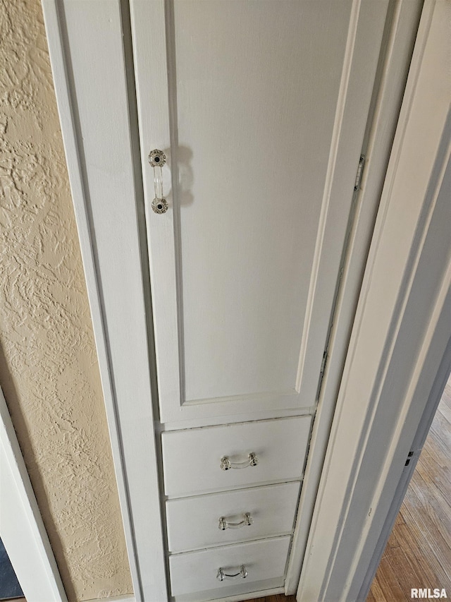 details with wood finished floors and a textured wall