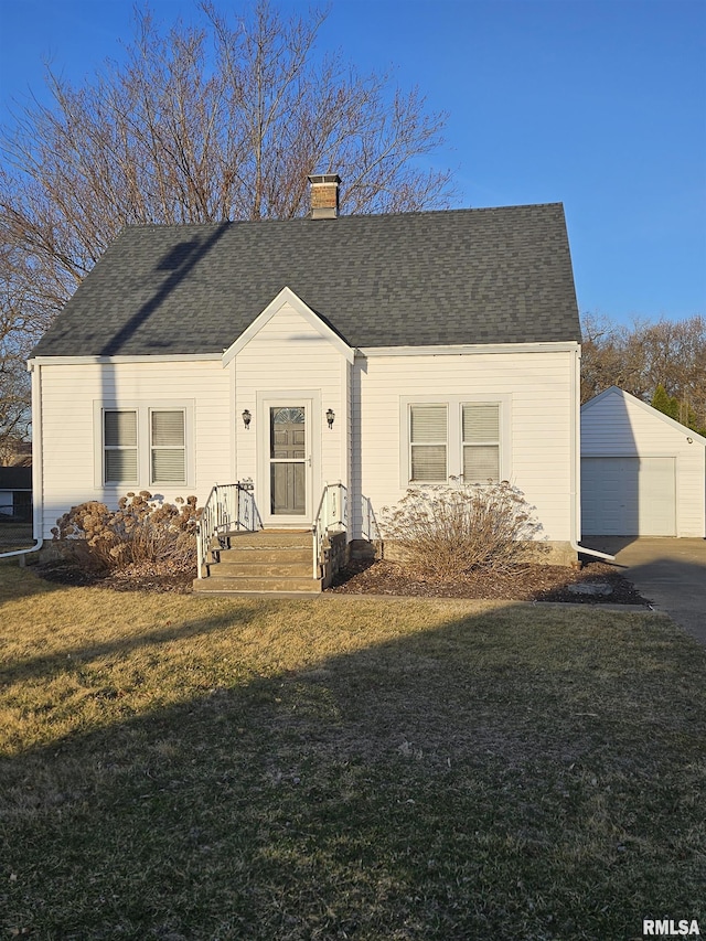 view of front of house with a front lawn, roof with shingles, a chimney, a garage, and an outdoor structure