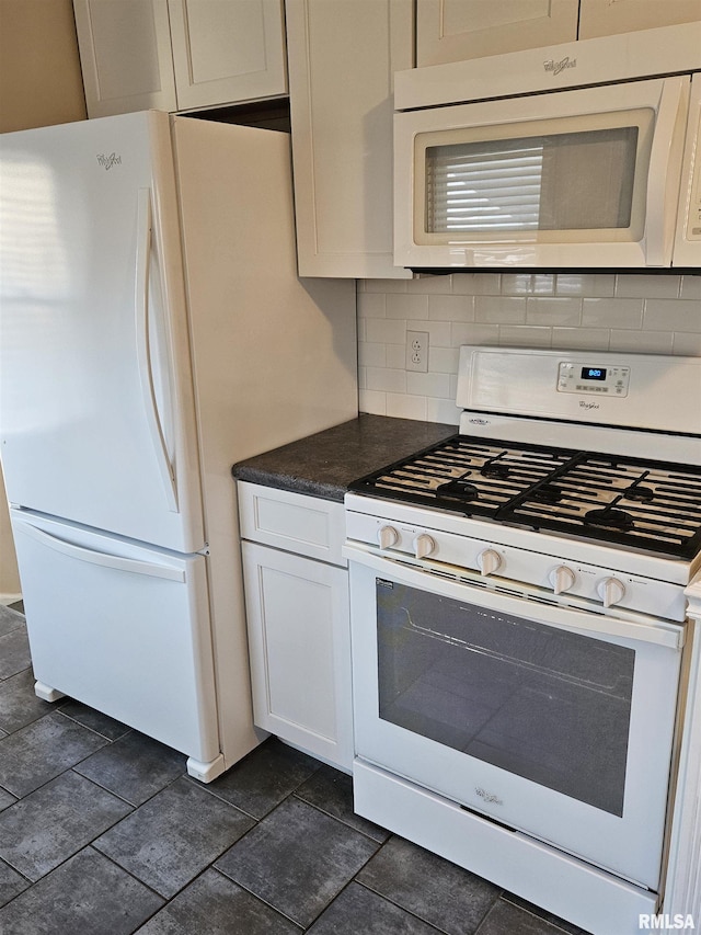 kitchen with dark countertops, white cabinetry, white appliances, and tasteful backsplash