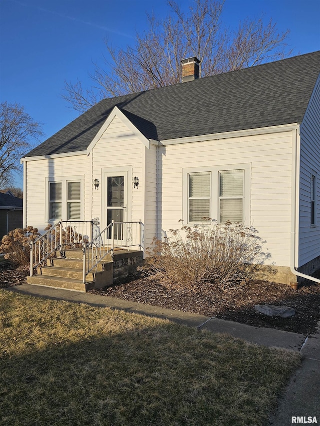 view of front of property featuring roof with shingles and a chimney