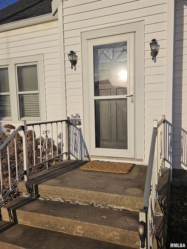 property entrance featuring roof with shingles