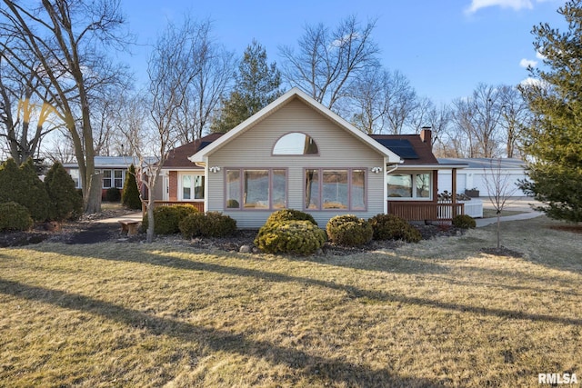 view of front of home with a chimney, solar panels, and a front yard