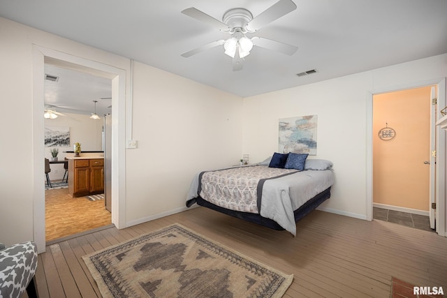 bedroom with light wood-type flooring, visible vents, baseboards, and ceiling fan