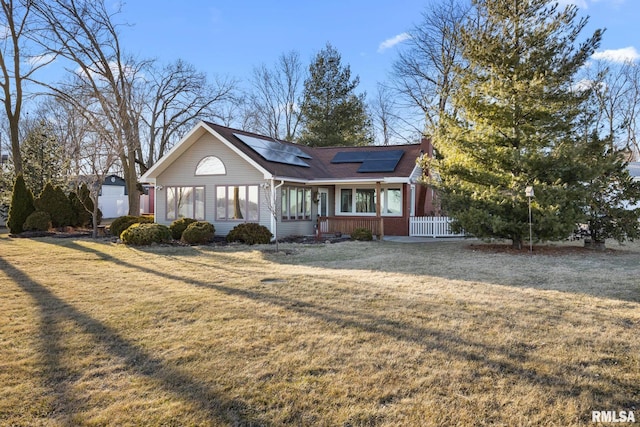 view of front of house with solar panels and a front yard