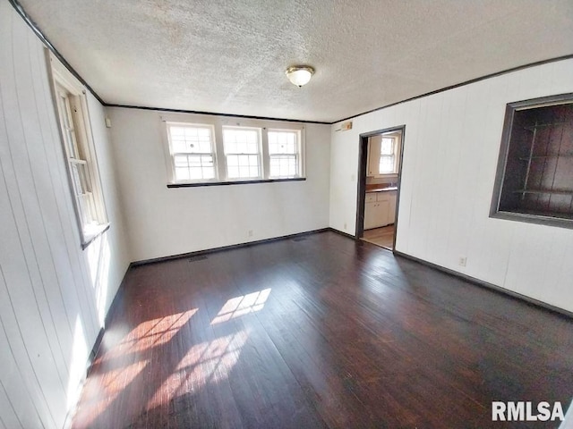 spare room with a textured ceiling and wood finished floors