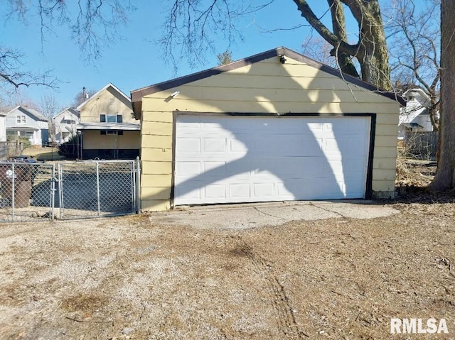 detached garage featuring a gate and fence