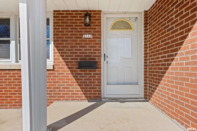 property entrance featuring brick siding