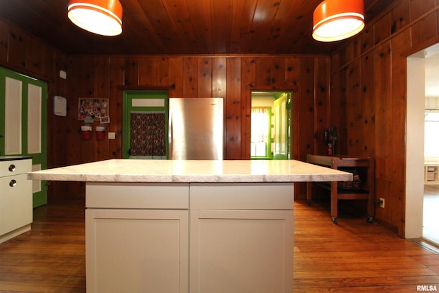 kitchen featuring wood finished floors, white cabinets, wood ceiling, and freestanding refrigerator