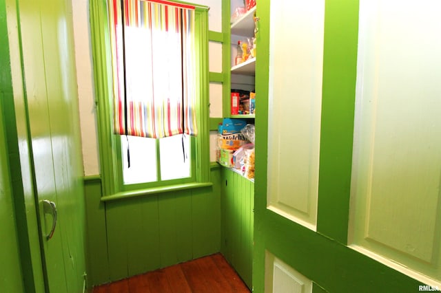 doorway to outside with dark wood finished floors and a wainscoted wall