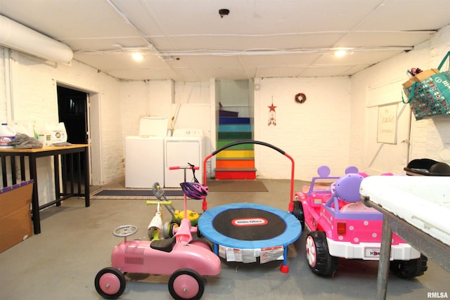 recreation room with concrete flooring and washing machine and dryer