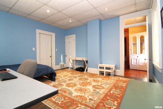 office space with a drop ceiling, baseboards, and wood finished floors