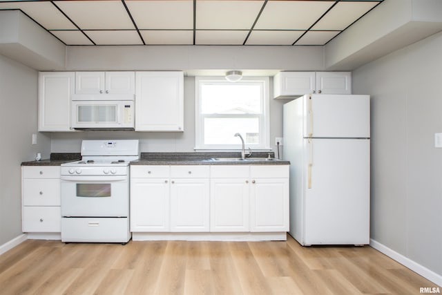 kitchen featuring white cabinets, white appliances, light wood-style floors, and a sink