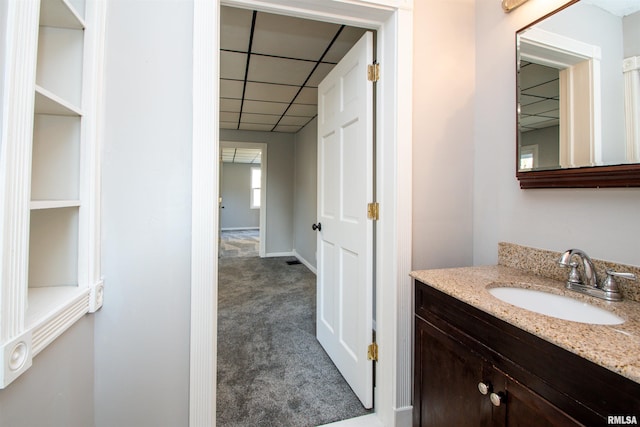 bathroom with a drop ceiling and vanity