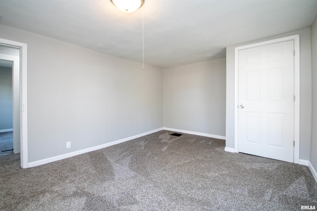 unfurnished room with carpet flooring and baseboards