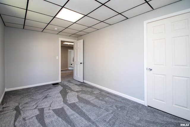 spare room with carpet, baseboards, and a drop ceiling