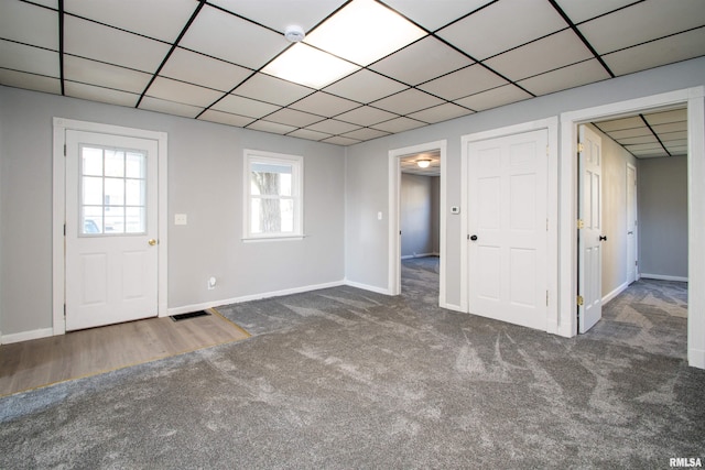 interior space featuring baseboards, carpet, visible vents, and a paneled ceiling