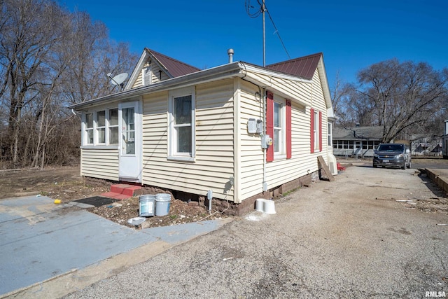 view of home's exterior with metal roof and driveway