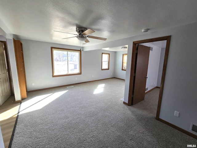 unfurnished bedroom with a textured ceiling, carpet, and baseboards