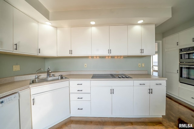 kitchen featuring a sink, stainless steel double oven, light countertops, black electric cooktop, and dishwasher