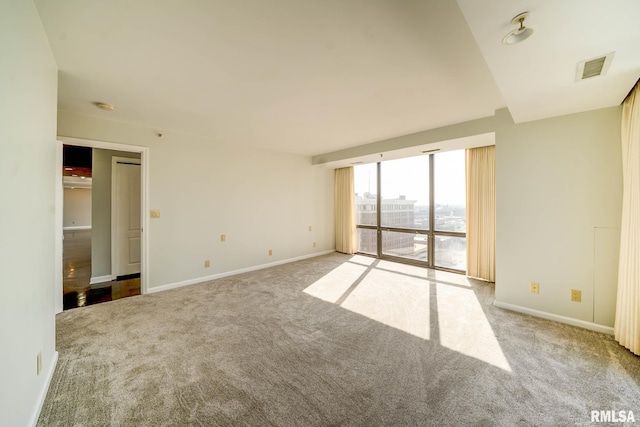 carpeted empty room featuring visible vents and baseboards