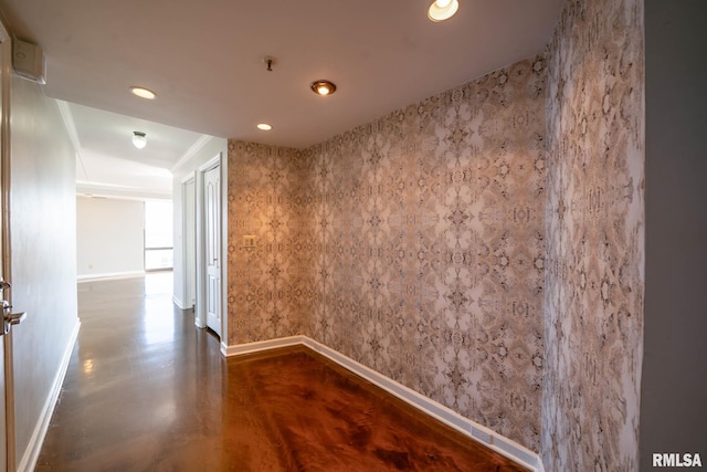 hallway with wallpapered walls, recessed lighting, finished concrete flooring, and baseboards