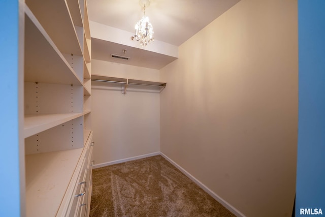 spacious closet featuring a notable chandelier, carpet flooring, and visible vents