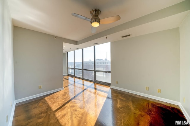 unfurnished room featuring visible vents, concrete floors, ceiling fan, baseboards, and a view of city