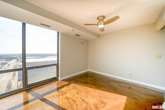 empty room featuring visible vents, ceiling fan, finished concrete flooring, and baseboards