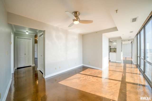 empty room featuring visible vents, baseboards, concrete flooring, and ceiling fan