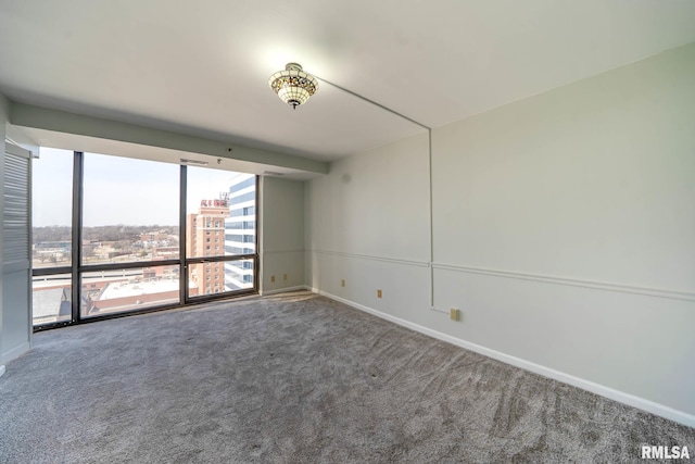 carpeted empty room featuring baseboards and a city view